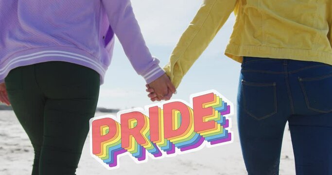 Animation of pride over hands of lesbian couple walking on beach