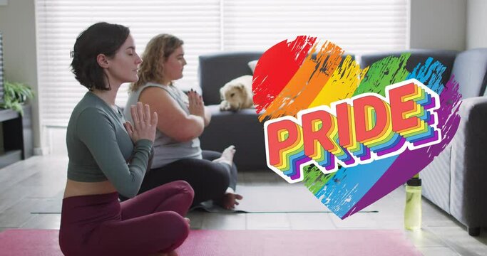 Animation of rainbow heart and pride over lesbian couple practicing yoga at home