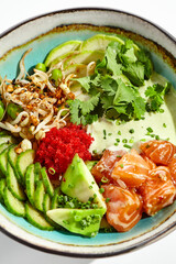 Healthy food - poke bowl with salmon, rice, cucumber, avocado, edamame beans, soybean sprouts and ponzu sauce. Hawaiian meal poke bowl with salmon isolated on white background.