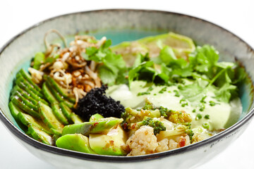 Vegan food - poke bowl with vegetables, edamame beans, soybean sprouts. Poke bowl with avocado and vegetables isolated on white background. Eat less meat. Plant - based eating.