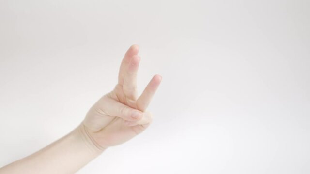 a woman's hand on a white background shows three and four fingers and claps her hands.