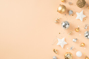 Top view photo of white golden and silver christmas tree decorations stars disco balls sequins and serpentine on isolated beige background with blank space