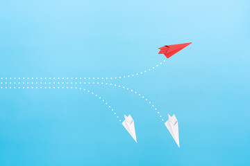 Successful red paper plane on blue background