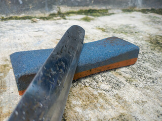 kitchen knife and whetstone on the concrete floor