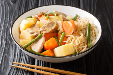 Delicious Homemade Japanese Cuisine Nikujaga meat and potatoes stew close up in bowl on the wooden background. Horizontal