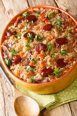 Arroz de Pato Portuguese Style Duck Rice with onion, carrot and chorizo close up in the baking dish on the wooden table. Vertical