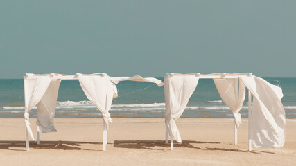 Sunny beach in late summer, gazebo by the sea