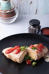 Omelette wrapped with bacon and tomato sauce