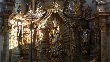 Fototapeta na wymiar Religious sculptures illuminated by a sunray. With mary and her child Jesus. Inside the church St. Alto und St. Birgitta. Symbol for faith, believe and hope.