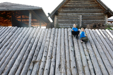 Two children sitting on wall of viking fortress