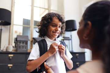 Boy smiling at mother as he gets ready for school