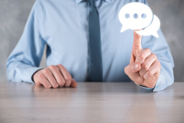 Businessman holding a message icon, bubble talk notification sign in his hands. Chat icon, sms icon, comments icon, speech bubbles