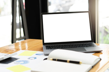 Side view of contemporary workplace with laptop computer, notebook, coffee cup and stationery on...