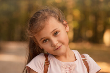 Portrait of a beautiful little girl in the autumn in the park