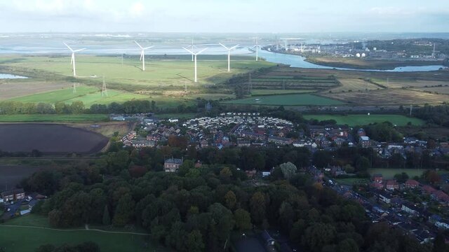 Cheshire farmland countryside wind farm turbines generating renewable green energy aerial view zoom in