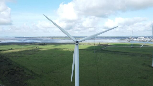Alternative green energy wind farm turbines spinning in Frodsham Cheshire fields aerial view