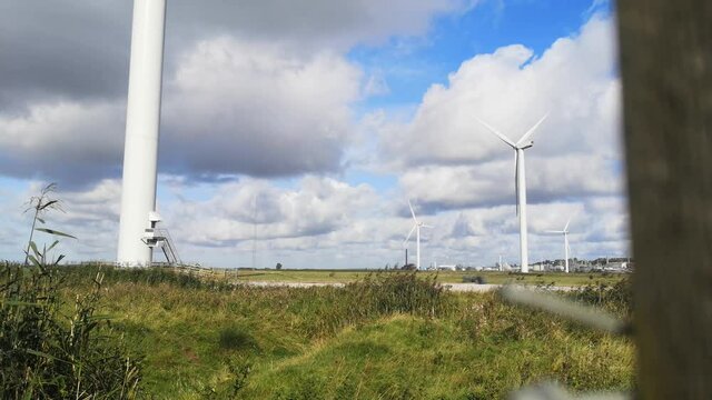 Alternative green energy wind farm turbines spinning on breezy Frodsham Cheshire grassland