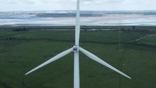 Alternative green energy wind farm turbines spinning in Frodsham Cheshire fields aerial view tilt up