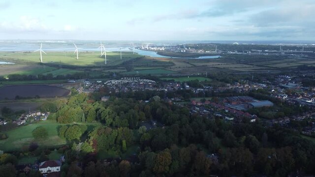 Cheshire farmland countryside wind farm turbines generating renewable green energy aerial view moving slow forward