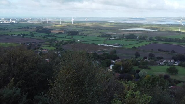 Cheshire farmland countryside wind farm turbines generating renewable green energy aerial view slowly panning right