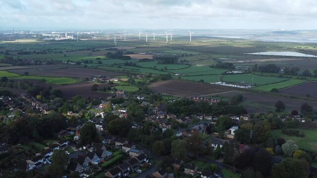 Cheshire farmland countryside wind farm turbines generating renewable green energy aerial view forward descent