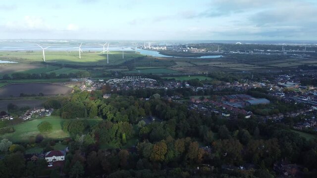 Cheshire farmland countryside wind farm turbines generating renewable green energy aerial view left panning shot