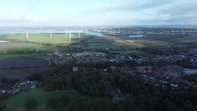 Cheshire farmland countryside wind farm turbines generating renewable green energy aerial view wide right orbit