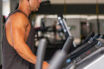 Young man in sportswear running on treadmill at gym.Handsome sport gym man running on the treadmill.Indoors shot.