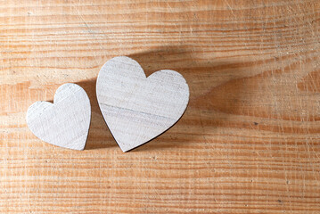 Two wooden handmade hearts placed on a brown wood board.Valentines day concept. Two hearts flat lay on wooden background. Greeting card concept. Top view. Copy space.Top view.