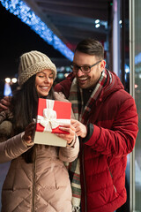 Young couple in love is celebrating with gift. Christmas birthday valentines day present concept