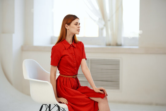 Pretty Woman In Red Dress Sitting Near The Window