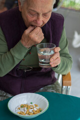 a handful of medicines that the old woman should take regularly. Selective Focus