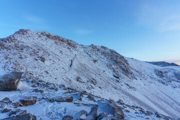 panoramic view man taking a photo with his phone at the top of the mountain