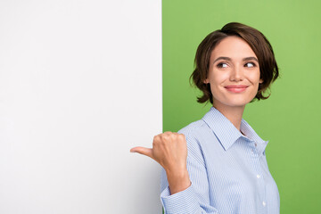 Photo of brunette bob haired young happy woman point finger thumb look empty space banner isolated...