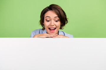 Photo of amazed positive young happy woman look empty space banner white copyspace isolated on...