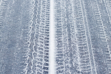Traces of the car on a snowy road in winter