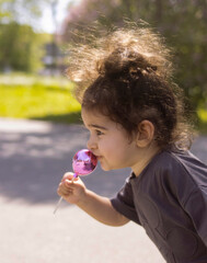 The girl plays with a toy in the street. Summer fun of a beautiful child.