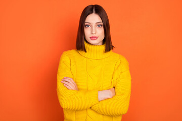 Photo of young woman serious confident crossed hands wear sweater isolated over orange color background