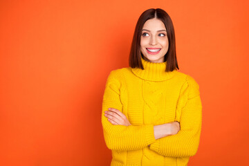 Photo of young attractive woman happy positive smile dream curious look empty space isolated over orange color background