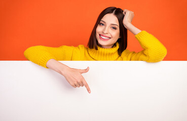 Photo of young woman happy positive smile point finger empty space poster ad promo choose isolated over orange color background