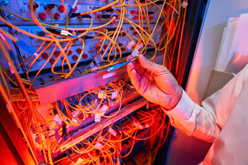 IT engineer connecting fiber-optic cable to server switch