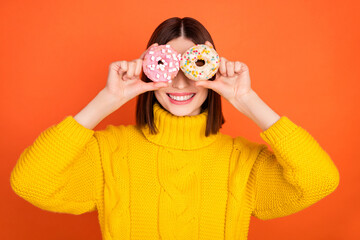 Photo of young woman happy positive smile cover eyes donut binoculars funky isolated over orange color background