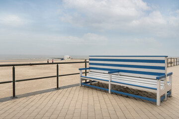 Fototapeta na wymiar Empty bench on the beach against the background of the sea.