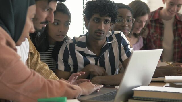 Happy focused students study foreign languages in class. Studying with laptop. Diverse multicultural young people study together, doing research