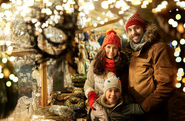 family, winter holidays and celebration concept - happy mother, father and little daughter at...