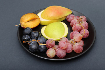 fresh fruits grape, plum, apple, pear in the plate