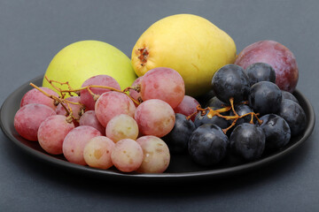 fresh fruits grape, plum, apple, pear in the plate