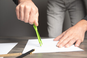 a man taking notes with a caliper on paper