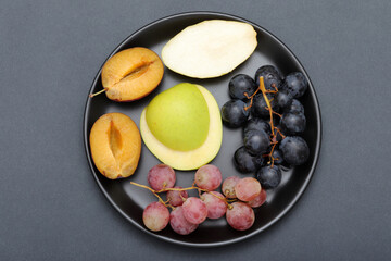 fresh fruits grape, plum, apple, pear in the plate