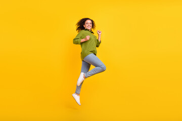 Fototapeta na wymiar Photo of attractive funny funky positive trendy lady wear green shirt running jumping high isolated yellow color background